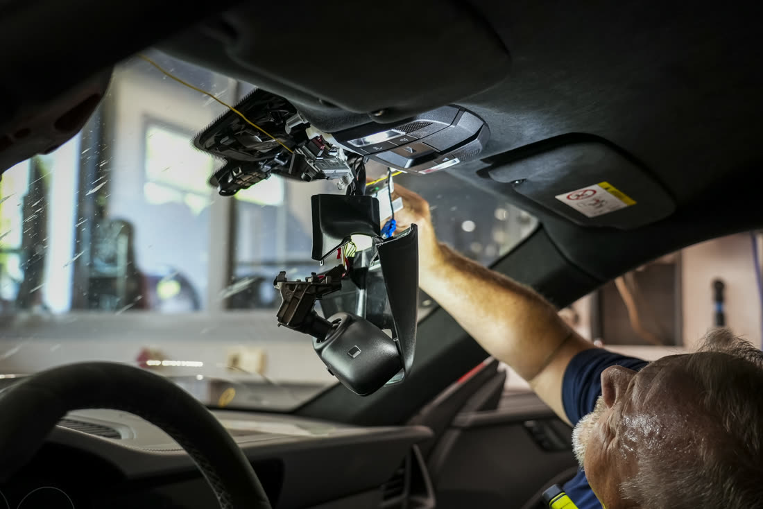 Mechaniker bei Arbeiten an der Frontscheibe eines Sportwagens