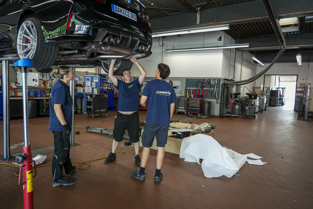 Team hebt ein Sportfahrzeug auf der Hebebühne